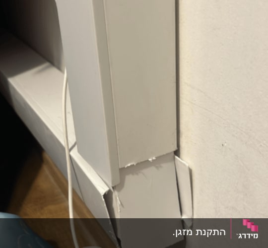 כבל חשמל ליד קיר עם תעלה לבנה